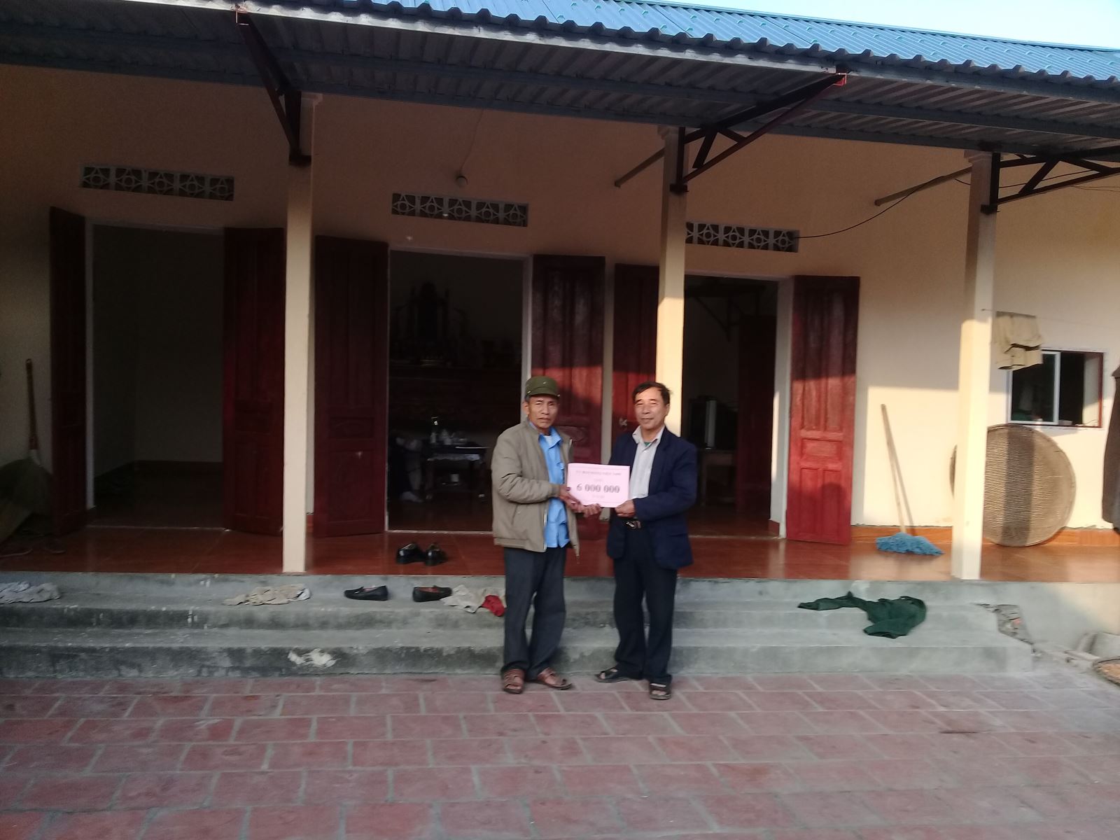 Ông Nguyễn Văn Thuấn (ảnh phải) tham gia hỗ trợ làm nhà cho hộ nghèo..	