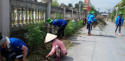 Hội Liên hiệp Phụ nữ xã Xuân Đông và sinh viên tình nguyện làm cỏ, trồng hoa tại đường huyện 24 đoạn qua địa bàn xã. Ảnh: Ngọc Duyên