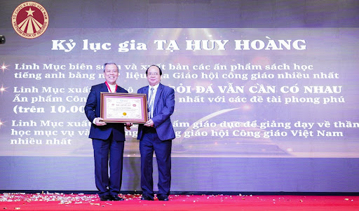 Chủ tịch Hội đồng Sáng lập Kỷ lục Việt Nam trao tặng bằng xác lập Kỷ lục đến linh mục Giuse Tạ Huy Hoàng. Ảnh: CTV