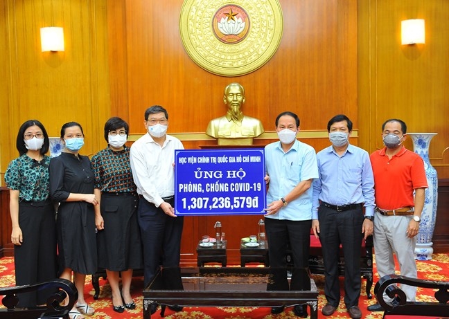 Lãnh đạo Ủy ban Trung ương MTTQ Việt Nam tiếp nhận ủng hộ từ Học viện Chính trị quốc gia Hồ Chí Minh. Ảnh: Nam Khánh