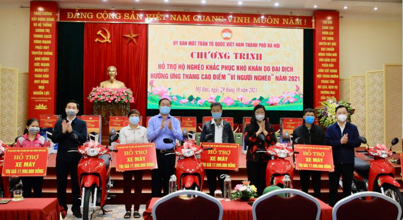 Bà Nguyễn Lan Hương cùng đại diện huyện Mỹ Đức tặng xe máy cho các hộ khó khăn. Ảnh: Phạm Cường