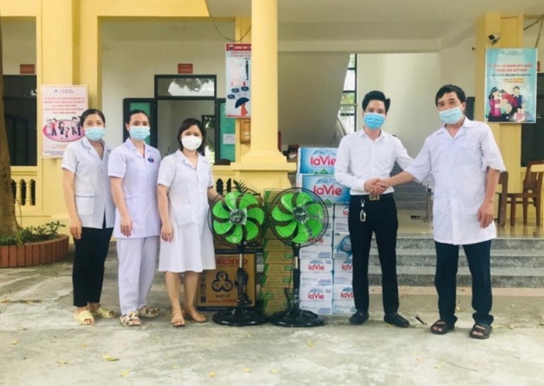 Giám đốc Công ty TNHH Hà Mai Vĩnh Phúc Phùng Văn Hà (đứng thứ hai từ phải sang) hỗ trợ đồ dùng cho cán bộ, y, bác sĩ trạm y tế của địa phương trong công tác phòng, chống dịch