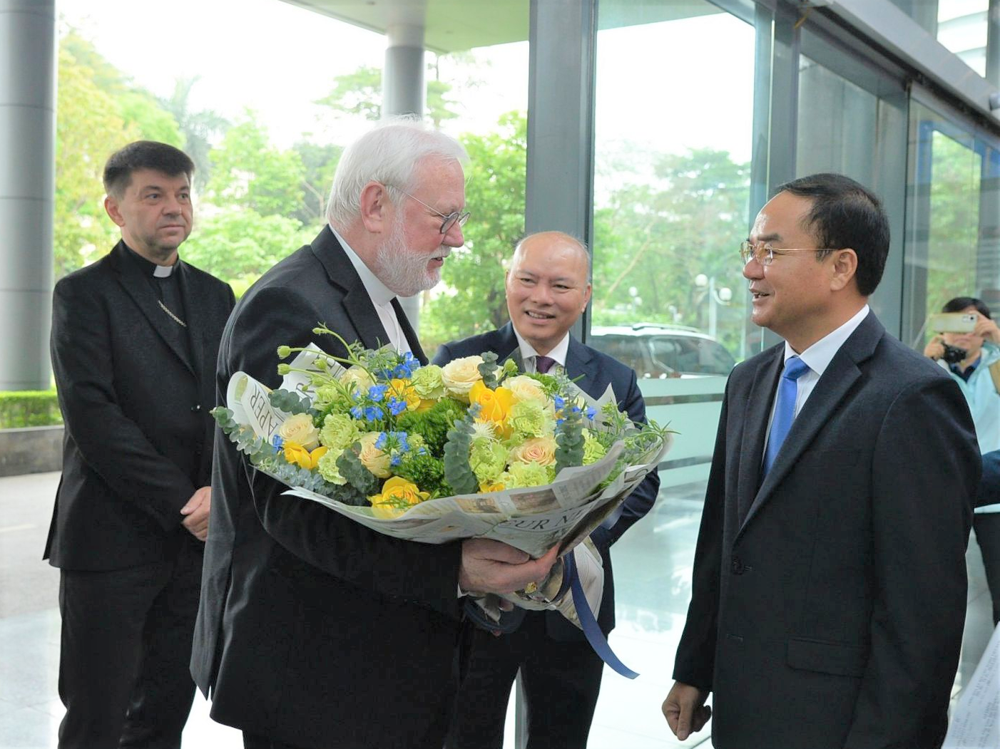Thứ trưởng Bộ Nội vụ Vũ Chiến Thắng (bên phải) tặng hoa chúc mừng Bộ trưởng Bộ Ngoại giao Tòa thánh Tổng Giám mục Paul Richard Gallagher