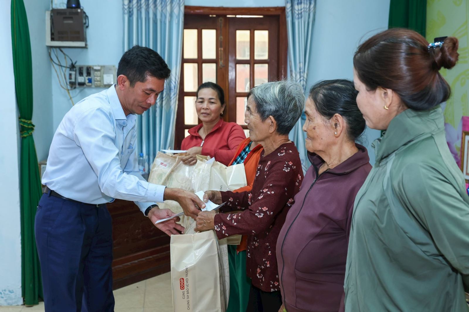 Ông Trần Đình Bình, thành viên Hội đồng quản trị Bệnh viện đa khoa quốc tế Nam Sài Gòn trao quà cho bà con.