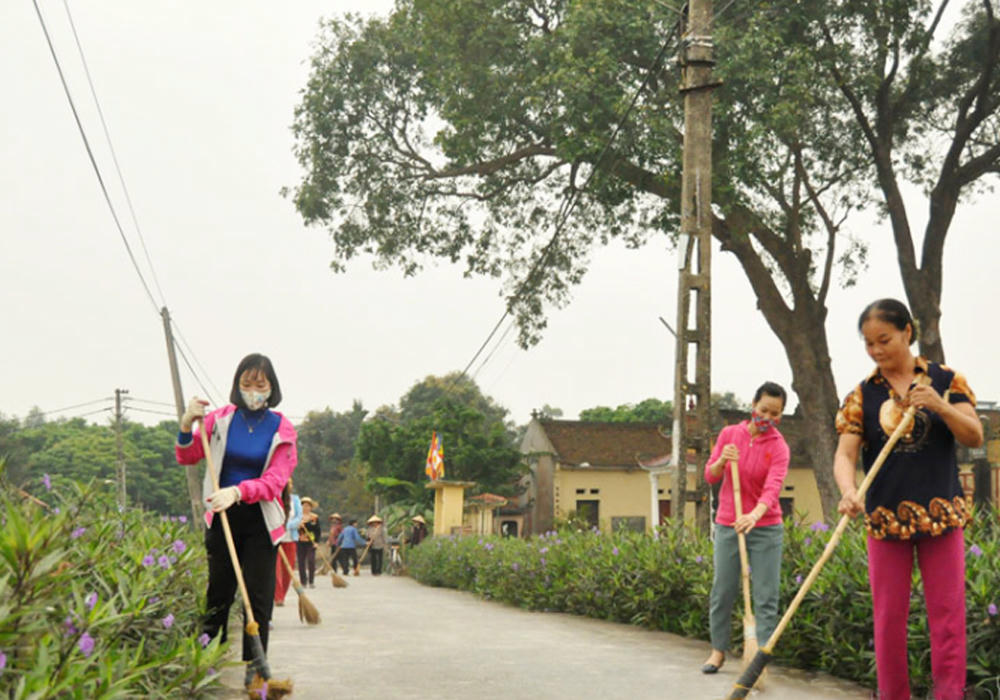 Người dân xã Gia Bình (tỉnh Bắc Ninh) vệ sinh, chăm sóc tuyến đường hoa, góp phần xây dựng nông thôn mới kiểu mẫu.