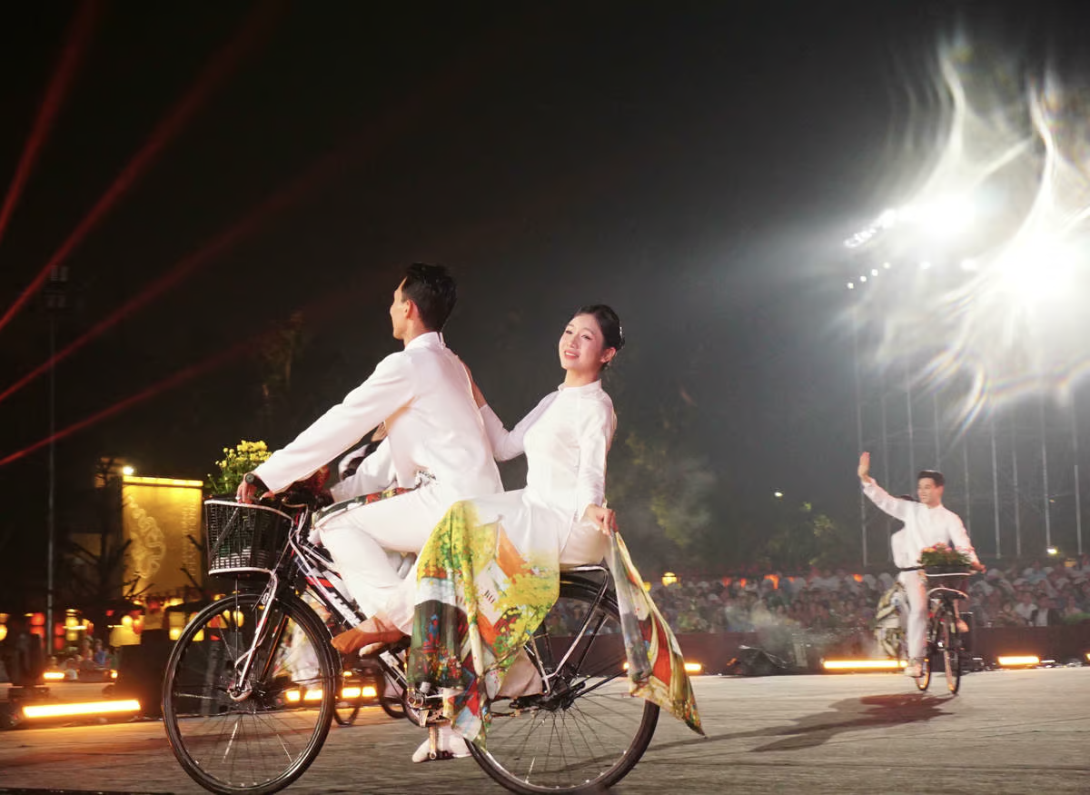 Hình ảnh những cô gái trong tà áo dài thướt tha đạp xe giữa không gian lễ hội gợi nhớ vẻ đẹp thanh lịch, nền nã - biểu tượng quen thuộc của Hà Nội xưa và nay.