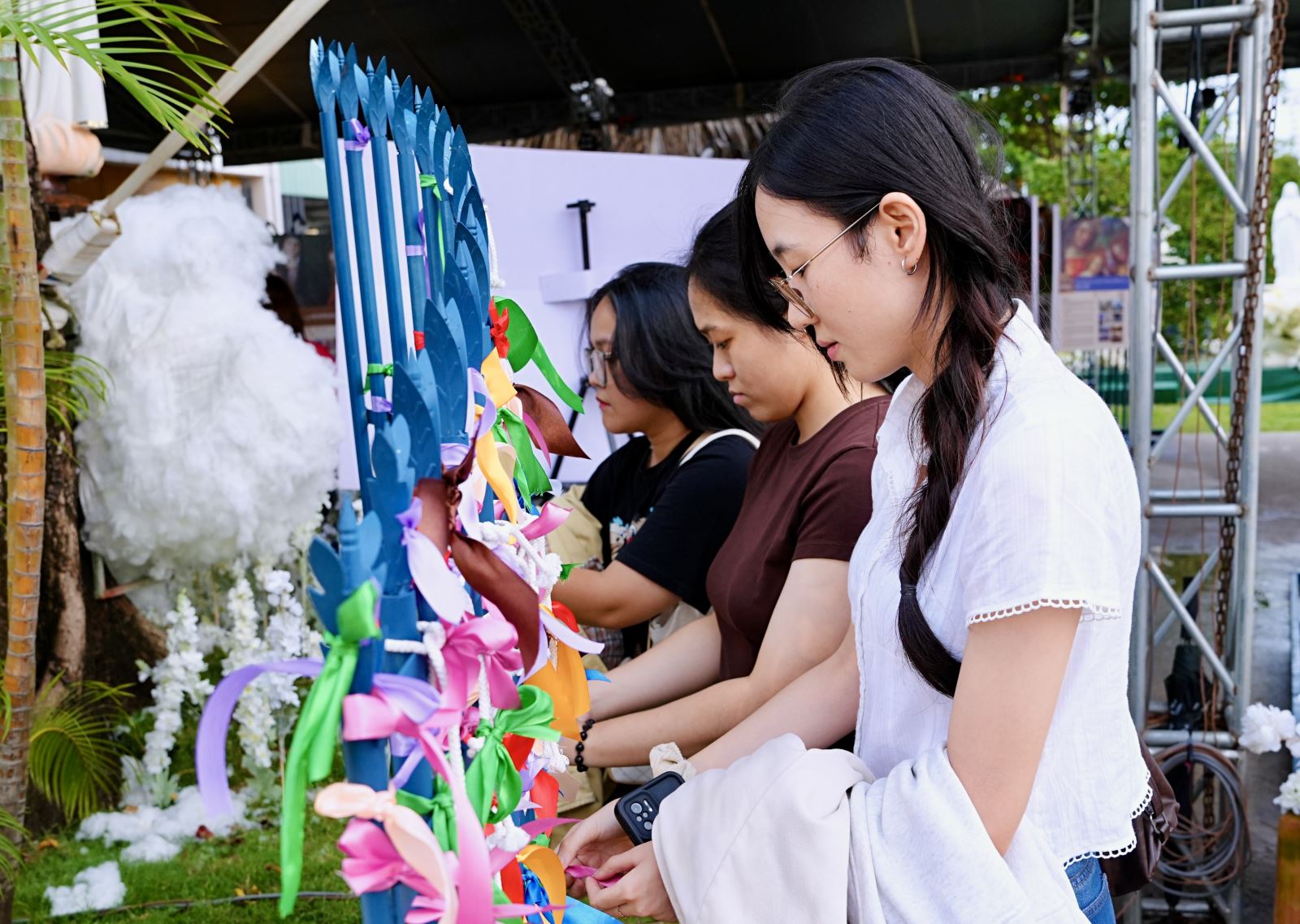 Người trẻ buộc các dải ruy-băng mang tâm tư, nguyện ước dưới chân đài tượng Đức Mẹ Tháo Gỡ Nút Thắt